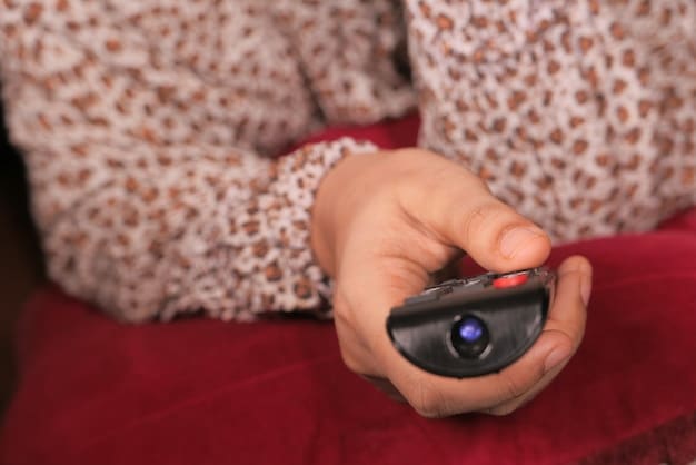 A close-up shot of someone's hand using a remote control to navigate a FAST streaming service on a smart TV. The interface displays a grid of channel options, each with different logos and content categories, highlighting the variety and accessibility of FAST channels.