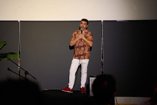 A director standing on a film set in Brazil, gesturing with their hands during a rehearsal. Crew members are around them, and the scene being filmed has a warm, golden-hour lighting. The director is dressed casually but confidently.