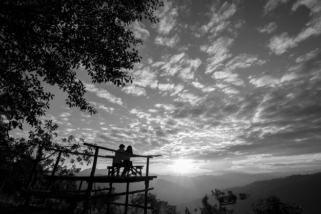 A black and white still from a Brazilian independent film, depicting a tense scene between two characters in a rural setting. The lighting is stark and the atmosphere intense.