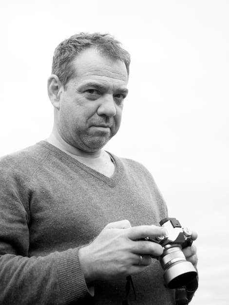 A black and white photograph of director Nelson Pereira dos Santos on the set of 