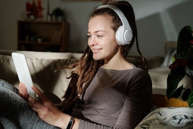 A person with a visual impairment wearing headphones, smiling while listening to a movie playing on a tablet, with subtle visual cues indicating an audio description track active on the screen.