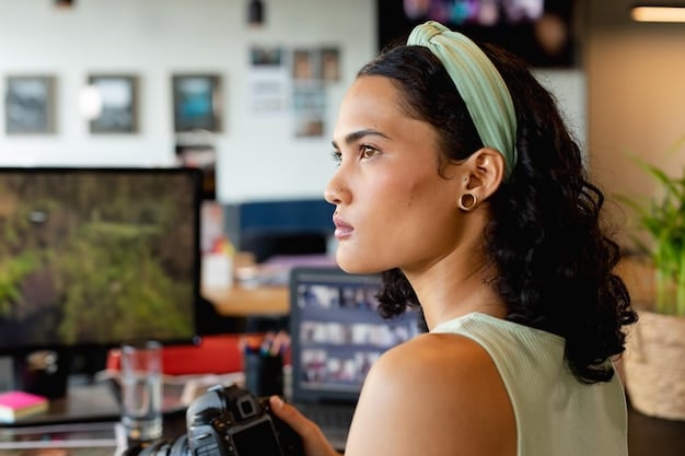 A Brazilian filmmaker looking thoughtfully at a computer screen displaying social media analytics graphs and charts, surrounded by film editing equipment.