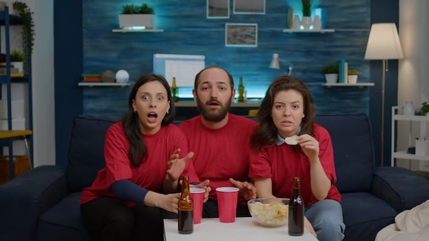 A group of friends watching a suspenseful TV show, their faces illuminated by the screen, reflecting the tension of a cliffhanger. A bowl of popcorn is overturned.