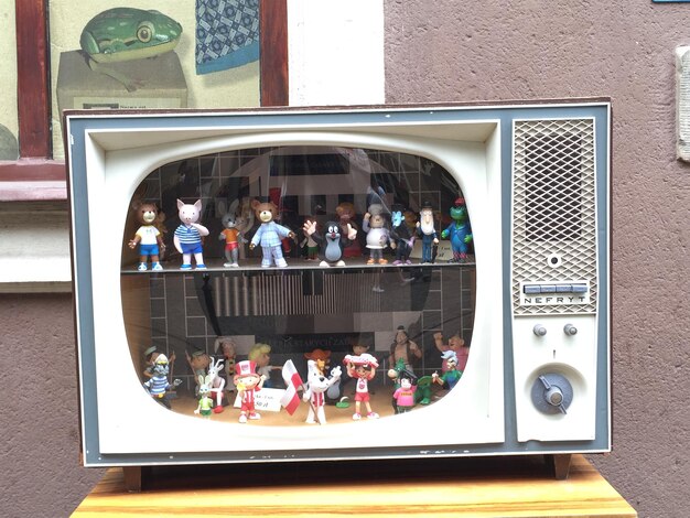 A vintage television set displayed in a museum exhibit, with placards detailing its cultural significance and impact on society, suggesting its role beyond mere entertainment.