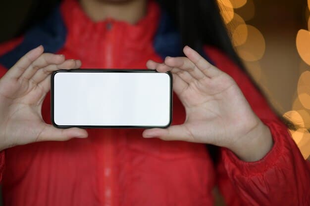 A person's hand holding a smartphone, with the screen displaying a blurred social media feed, symbolizing the use of spoiler-blocking apps or features. The background is dimly lit, suggesting a focused, immersive viewing experience.