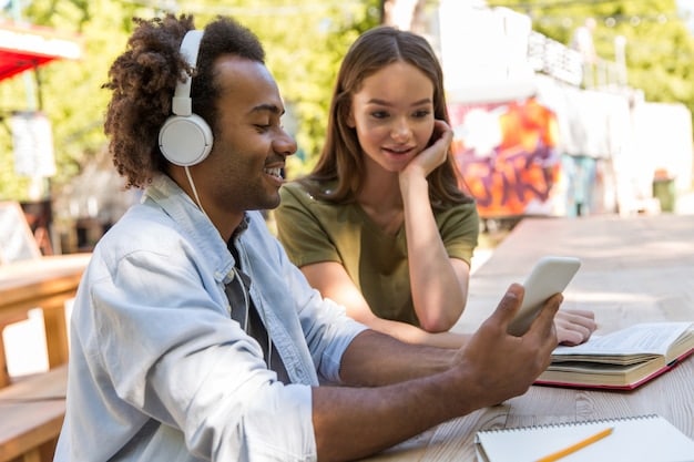 A diverse group of friends gathered around a tablet, sharing headphones and smiling, indicating a shared, respectful viewing experience and fostering community.