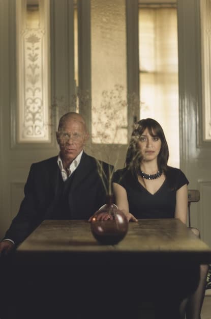 A still from a Brazilian drama series depicting a tense courtroom scene with lawyers arguing and the accused looking worried. The image has a dramatic lighting and intense atmosphere, highlighting the serious nature of the show.