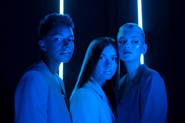 A diverse group of actors in subtle, futuristic attire standing in a dimly lit, high-tech control room, their expressions conveying a sense of quiet intensity and determination.
