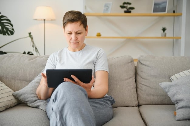 A person sitting on a couch, looking at a tablet with a focused expression. The tablet displays a social media feed with blurred content due to a spoiler-blocking browser extension. The background shows a movie marathon setup with snacks and drinks. Illustrates digital tools to enjoy a movie marathon spoiler-free: A guide to watching multiple films without getting anything ruined in BR