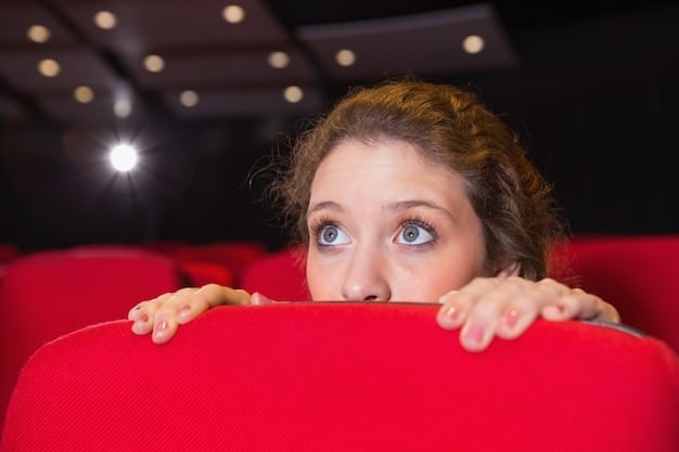 A close-up of someone's eyes wide with surprise while watching a movie trailer on a laptop. The reflection of the laptop screen is visible in their eyes, showing scenes of suspense and action. This scene illustrates the intensity of spoiler-free movie predictions: how to guess what will happen without reading spoilers in 2025.