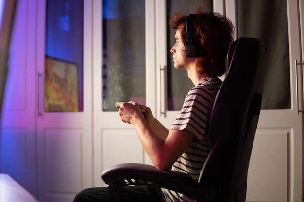 A person sitting on a couch, eyes closed, deeply immersed in listening to a movie soundtrack, with the movie poster blurred in the background. The scene conveys relaxation and focus on the music.