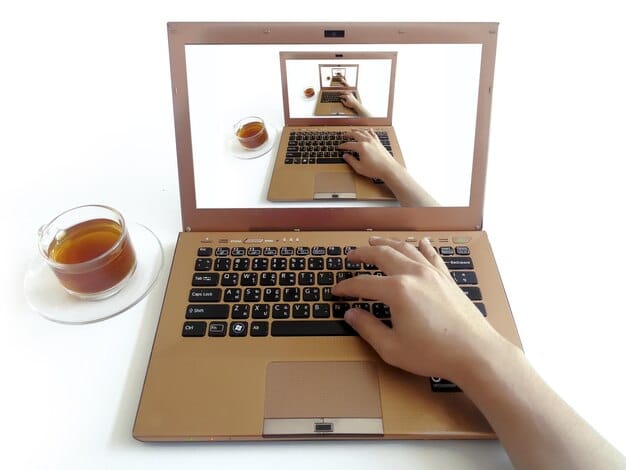 A hand hovering over a laptop screen, about to click away from a social media spoiler. The background shows blurred social media icons, emphasizing the effort to avoid unwanted content. The lighting is slightly dramatic to underscore the tension of avoiding spoilers, related to 